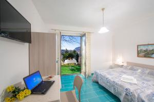 a bedroom with a bed and a desk with a laptop at La Casetta in Agerola