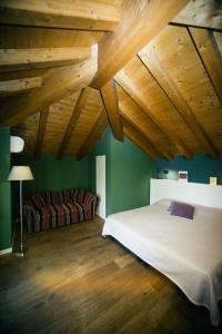 1 dormitorio con cama, sofá y techos de madera en Locanda Cece e Simo en Bergamo