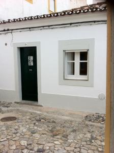 a white building with a black door and a window at Casinha alentejana in Évora