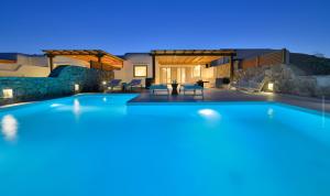 a swimming pool in a villa at night at Villa Kimothoe by Thalassa Residence Mykonos in Elia Beach