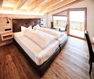 a large bedroom with a large bed and a desk at Alpen Boutique Hotel Alpetta in Nauders