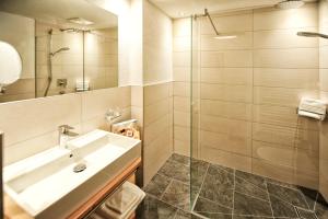 a bathroom with a sink and a glass shower at Alpen Boutique Hotel Alpetta in Nauders +24 photos