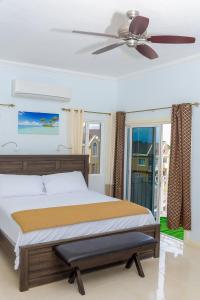 een slaapkamer met een bed en een plafondventilator bij Tropical Luxury Dreams in Ocho Rios