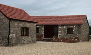 un bâtiment en briques avec un toit rouge dans l'établissement Sedbury Farm Cottages, à Chepstow