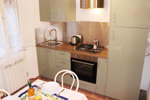 eine kleine Küche mit einem Tisch und einem Kühlschrank in der Unterkunft Pancotto - Appartamento nel cuore di San Gimignano in San Gimignano