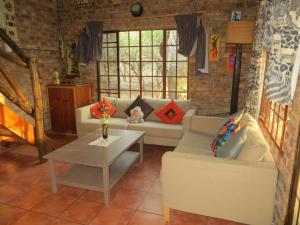 un soggiorno con divano e tavolo di Kruger Safari Animal Encounter a Marloth Park
