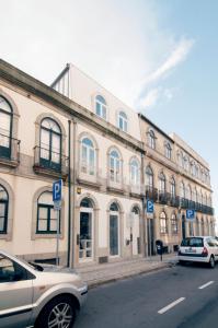 two cars parked in front of a large building at Flattered to be in Porto in Porto