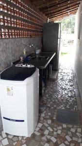 a kitchen with a sink and a trash can at Kitnets Capri in Caraguatatuba +113 photos