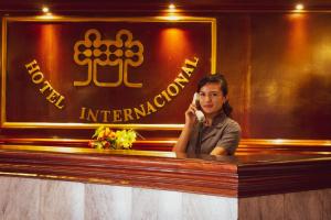 a woman talking on a cell phone at a bar at Hotel Internacional in Lima