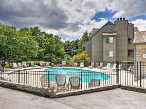 a swimming pool with chairs and a house at Gatlinburg Mountain Condo in Gatlinburg