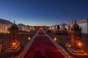 a long aisle with lights and tents in the desert at Sahara Majestic Luxury Camp in Merzouga