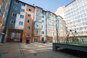 plac zabaw w mieście z wysokimi budynkami w obiekcie Apartment in center premium w Iwano-Frankiwsku