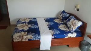 a bed in a room with a blue comforter at Chez Sabine in Abomey