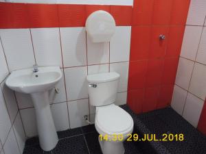 y baño con aseo y lavamanos. en Hospedaje Mas, en Tarapoto