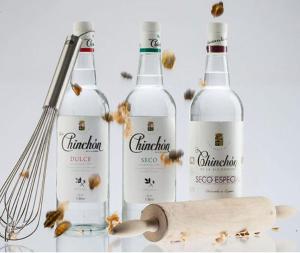three bottles of wine sitting next to a whisk at El Patrón in Chinchón