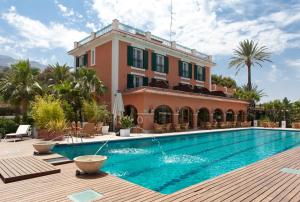 a villa with a swimming pool in front of a building at Hotel MR Les Rotes in Denia