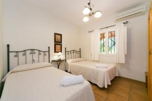 a bedroom with two beds and a window at Casa Rural La Cambreta in Crevillente