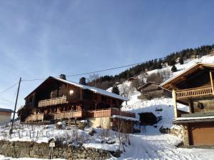 a large wooden cabin in the snow with snow covered at La Ferme Des Favrays in Notre-Dame-de-Bellecombe