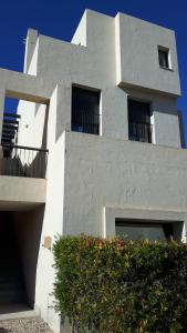 un edificio blanco con balcones en un lateral en Casa Patrick, en Murcia