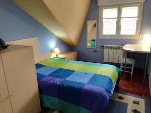una camera con un letto colorato e un lavandino di Chalet Argoños ad Argoños