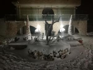 un cortile coperto di neve con un albero e luci di Villa del sole a Gravina in Puglia