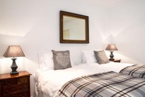 a bedroom with two beds and a mirror on the wall at Beach View, Waterside Cottages in Alnmouth
