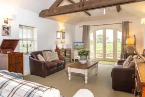 a living room with a couch and a table at Beach View, Waterside Cottages in Alnmouth
