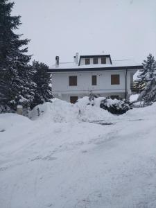 dom z kupą śniegu przed nim w obiekcie Condominio Esagono w mieście Pescocostanzo