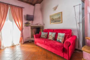 un divano rosso in un soggiorno con camino di Bargello Florence a Firenze