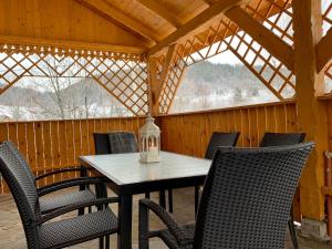 a table and chairs in a screened porch with a lantern at Willa Beskidzka in Myślenice