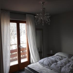 Giustino的住宿－Felix，一间卧室设有一张床、一个窗户和一个吊灯。