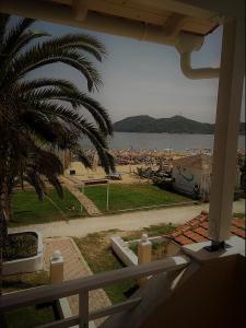 a view of a beach from a house with a palm tree at Marinis Boutique Rooms in Iraklitsa