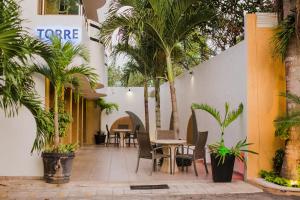 a courtyard with palm trees and tables and chairs at Hotel & Suites Country Valladolid in Valladolid