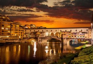 フィレンツェにあるAppartamento con terrazza in Santa Maria Novellaの日没時の川橋