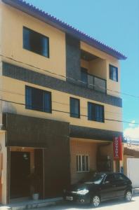 a black car parked in front of a building at Pousada NP in Conceição da Barra