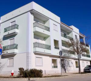 ein weißes Gebäude mit Balkon auf der Seite in der Unterkunft Central apartment-terrace and pool in Cabanas de Tavira