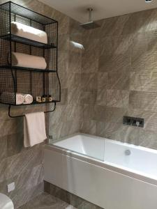 a bathroom with a tub and a towel rack and towels at Charter House in Newport