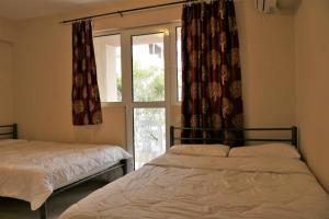 two beds in a room with a window at Mango in Paralia Katerinis