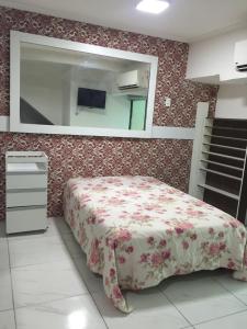 1 dormitorio con cama y espejo en Loft Morada do Porto, en Salvador