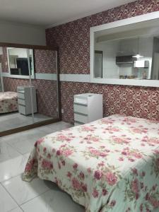 1 dormitorio con cama y espejo grande en Loft Morada do Porto, en Salvador