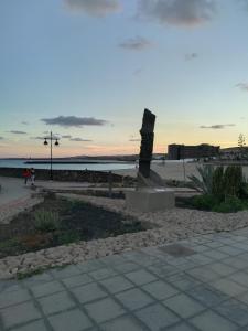 una statua sulla spiaggia con l'oceano sullo sfondo di fuerteventura oceano azul a Puerto del Rosario