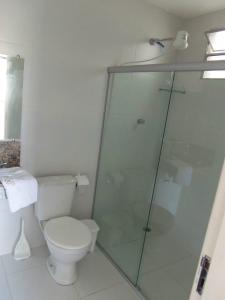 a bathroom with a toilet and a glass shower at Pousada Águia in Vera Cruz de Itaparica