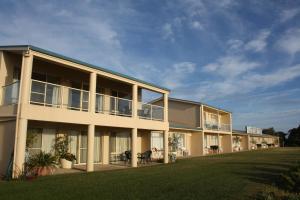 un grand bâtiment avec une pelouse devant lui dans l'établissement Lakeview Motel and Apartments, à Robe