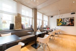un restaurant avec des tables, des chaises et des fenêtres dans l'établissement La Pipistrelle Hotel, à Luxembourg