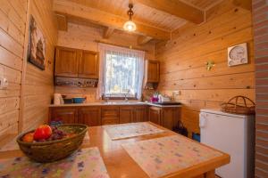 a kitchen with a table and a bowl of fruit at Komfortowe Domki na Roztoczu- Domek Majdan in Majdan Sopocki