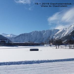 a snow covered field with mountains in the background at Ferienwohnung Klein&Fein in Bad Aussee