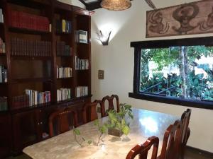 a dining room with a table and chairs and a window at Pousada Buieié in Lavras Novas