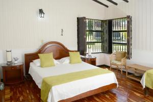 Un dormitorio con una cama grande y dos ventanas. en Casa Finca Corales Llano Grande 1, en Rionegro