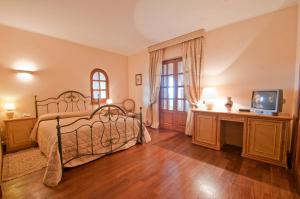 a bedroom with a bed and a tv on a wooden floor at Tenuta Cusmano in Grottaferrata