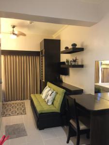 a living room with a green couch and a table at Studio Unit Cityland Prime Residence in Tagaytay